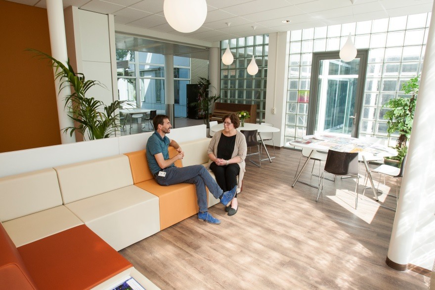 stoelen en tafeltjes en een ruime bank in de gastvrije ruimte