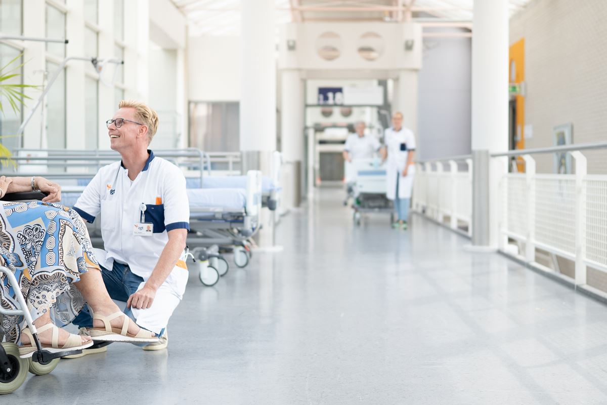Vrouwelijke patient in rolstoel in gesprek met verpleegkundige Vrouwelijke patient in rolstoel in gesprek met verpleegkundige